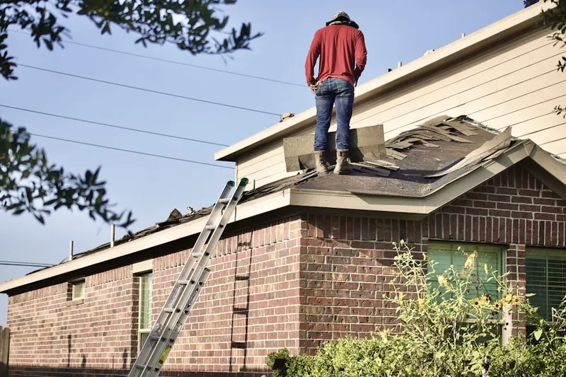 Professional roofer working on a residential roof in Ashley